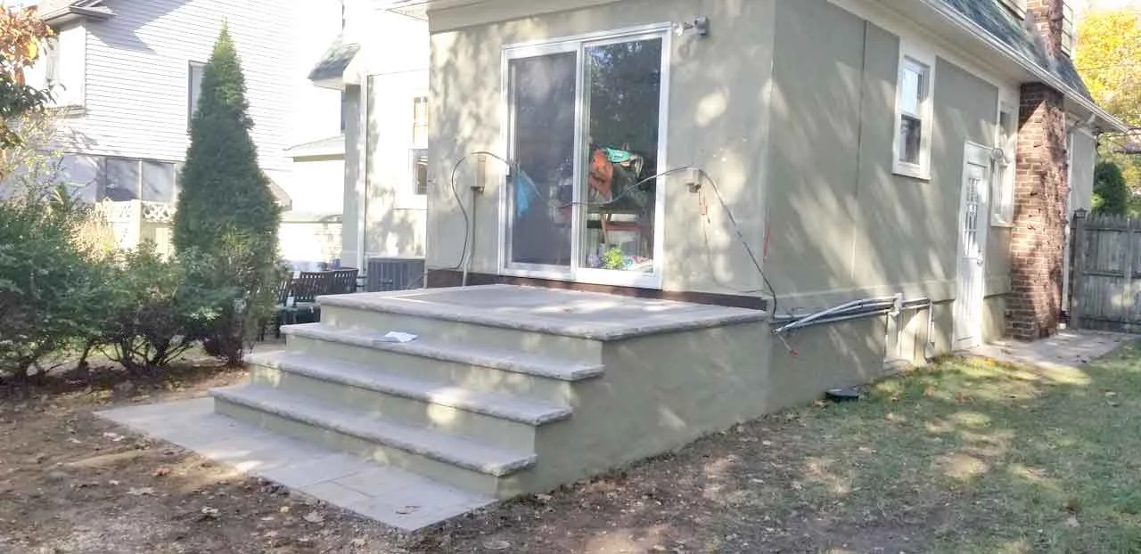 Concrete steps and landing beside a home from AJT’s masonry project gallery